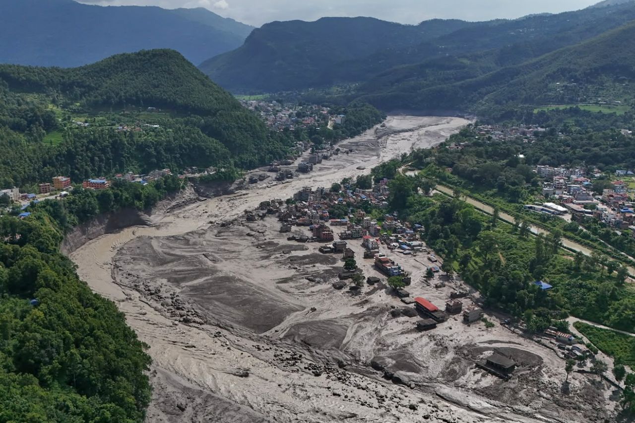 Damaged houses stand precariously near the swollen, debris-choked banks of the Trishuli River after flash floods in Nepal's Nuwakot district on Wednesday, Aug. 26.