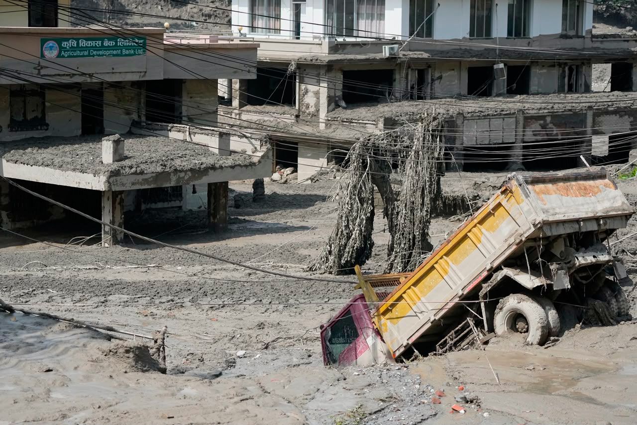 Damaged houses and vehicles are seen in the aftermath of flash floods along the Trishuli River in Nepal's Nuwakot district, Wednesday, Aug. 26.