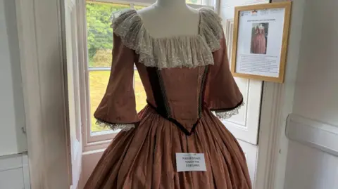 An ornate pink dress on a mannequin
