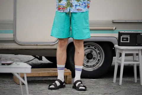 Getty Images Man wearing green shorts, socks and sandals
