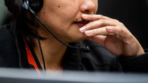 Bloomberg via Getty Images File picture of an employee speaking on the phone as she works in a Manila call centre.