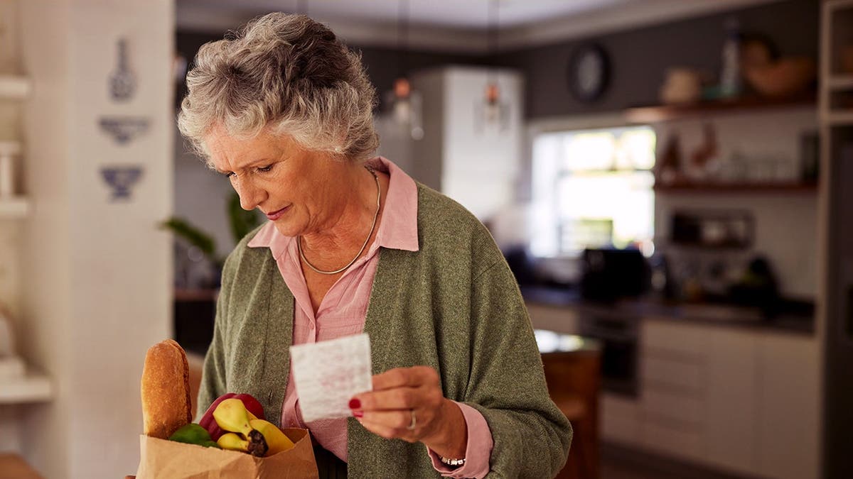 A baby boomer analyzes her grocery-store receipt.