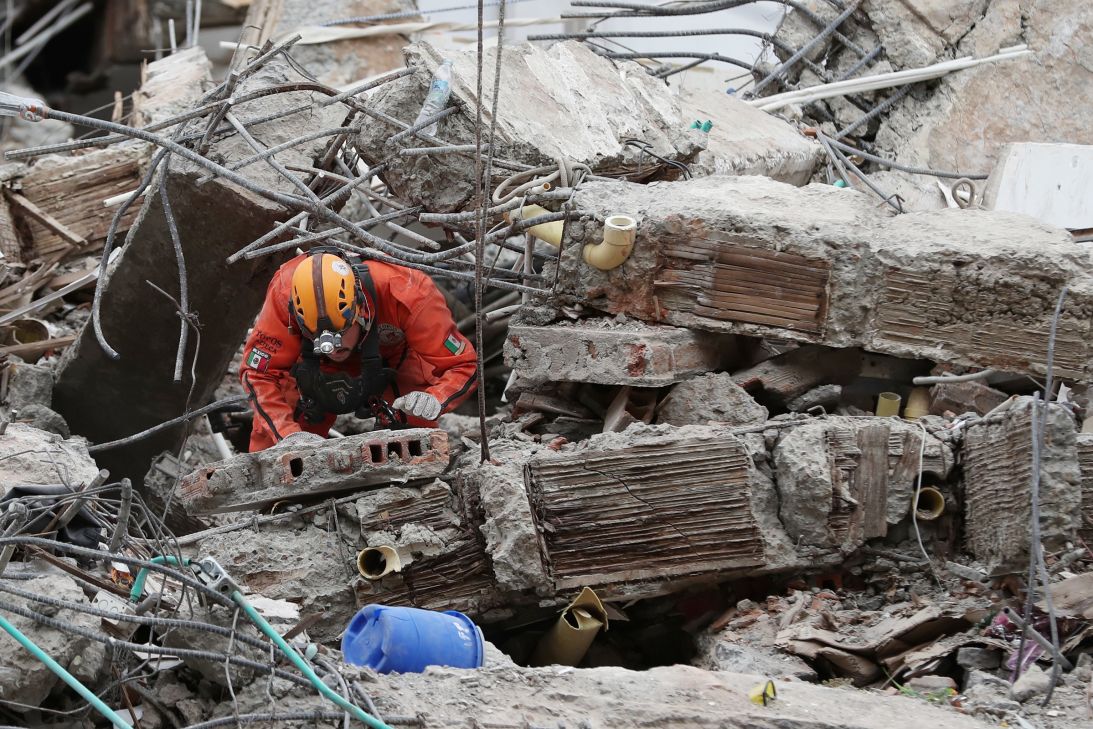 A Mexican rescue worker searches through the rubble two days after an earthquake struck Cali, Colombia, on August 12.
