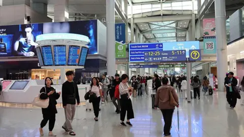 Getty Images Passengers walking in the departure hall at Incheon airport