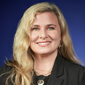 Rachel Whitmer, wearing a black shirt, smiles at the camera.