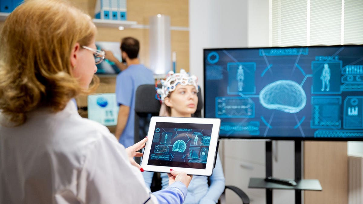 Doctor views a brain scan on a tablet in a laboratory.