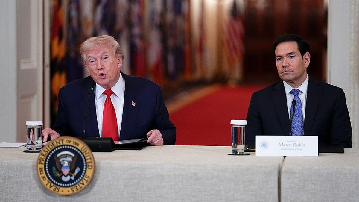 President Donald Trump and Secretary of State Marco Rubio seated during a roundtable in the White House East Room