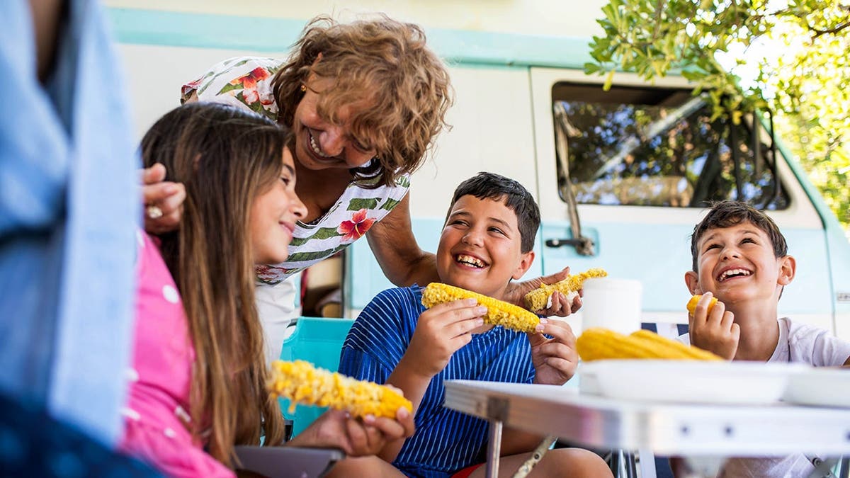 A family eats corn on the cob together.
