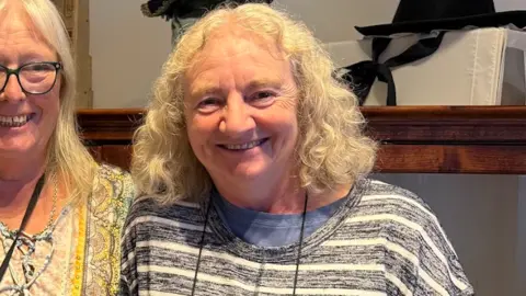 A woman with a stripy shirt and curly light hair