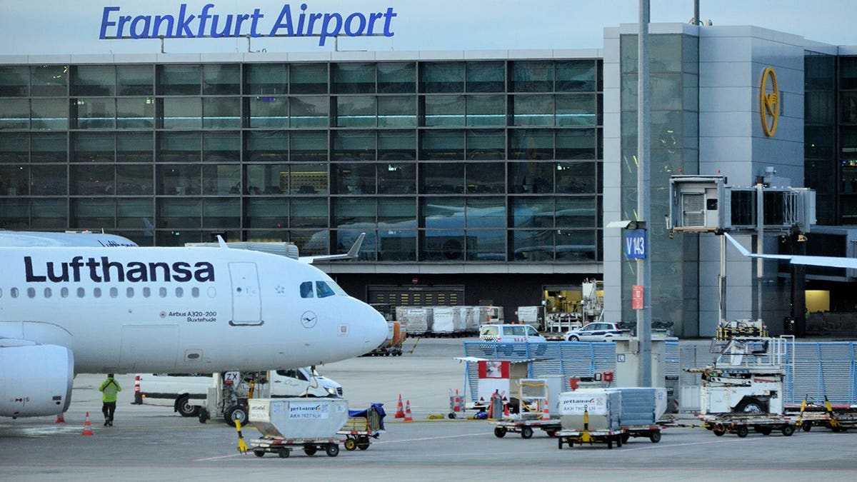 Lufthansa Airbus A320 aircraft parked at Remote Stand V143 beside the Frankfurt Airport terminal.