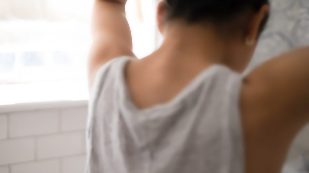 blurred image of person seen from the back dressing their hair