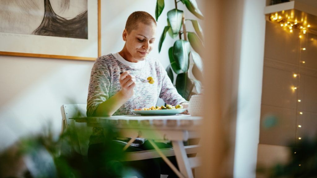 A person sitting at a table and looking at food on a fork.2
