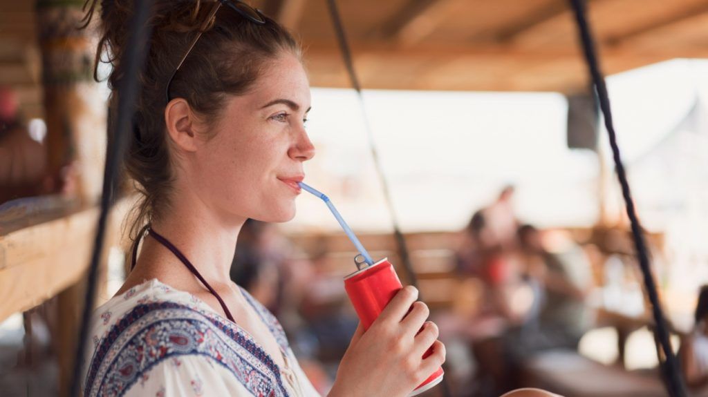 A person drinking soda from a can.