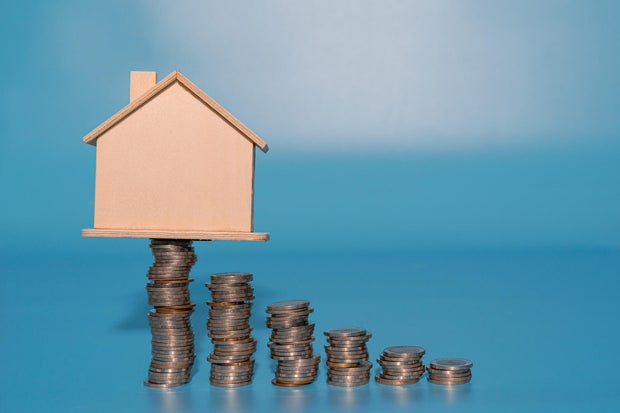 House model on top of coins stacks. Save and investment money concept.