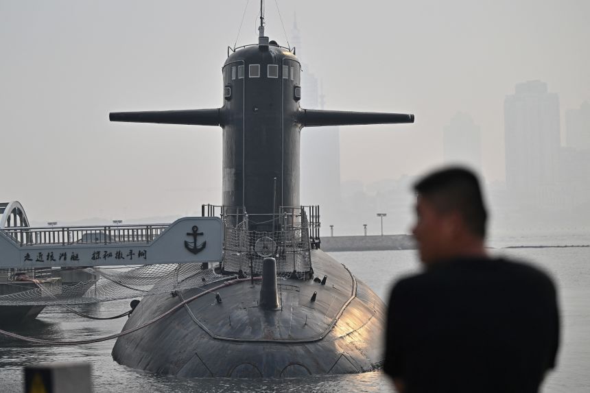 A man looks at a submarine during a media tour by the PLA Naval Museum, organized by the Chinese People's Liberation Army Navy (PLAN) in Qingdao, in eastern China's Shandong province on June 25, 2025.