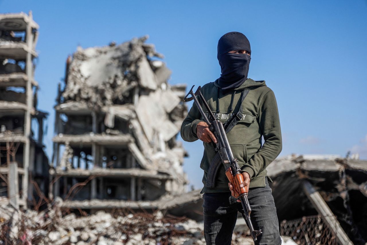 A Hamas militant stands guard as Egyptian workers and members of the International Committee of the Red Cross (ICRC) search for the last two remaining bodies of Israeli hostages under the rubble of the Jabalia refugee camp, Gaza, on December 1.