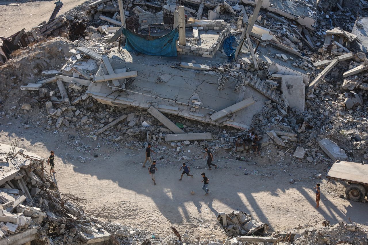 Children play football amid the ruins of destroyed buildings in Gaza City on July 27.