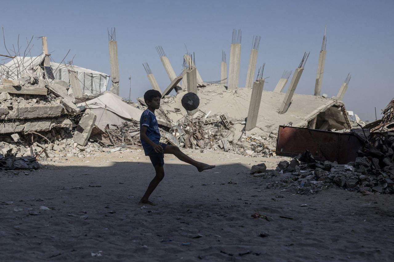 A Palestinian boy juggles a ball in front of a destroyed building in Khan Yunis in the southern Gaza Strip on July 31, 2026. Hamas said on Friday.