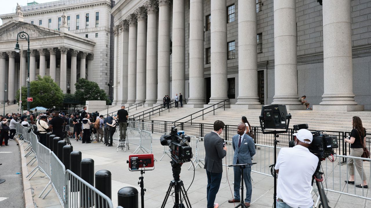 NEW YORK, NEW YORK - AUGUST 14: Members of the press report from the front of Thurgood Marshall United States Courthouse ahead of a Luigi Mangione court hearing on August 14, 2026 in New York City. Mangione is set to appear in court for his federal case, where he is expected to plead guilty to two federal counts of stalking. He is accused of fatally shooting UnitedHealthcare CEO Brian Thompson on Dec. 4, 2024, in Midtown Manhattan. Mangione has pleaded not guilty to the state charges. (Photo by Michael M. Santiago/Getty Images)