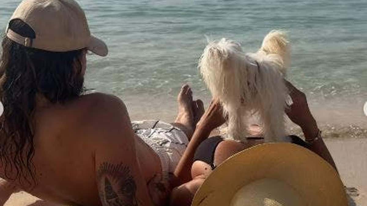 Heidi Klum lying on a beach with husband and dog.