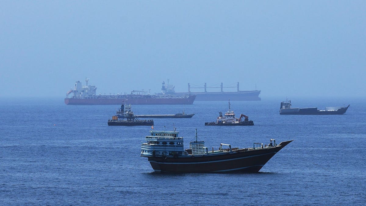 A view of commercial cargo vessels and crude oil tankers are anchored in the Gulf of Oman, off the coast of Muscat, Oman, on June 21, 2026, as they prepare to transit through the critical Strait of Hormuz. Maritime traffic along this vital global trade corridor experienced severe disruptions following heightened geopolitical tensions between the United States and Iran that escalated earlier in February. Following a diplomatic memorandum of understanding reached in mid-June, the strategic waterway is expected to fully reopen to international shipping and energy transit.