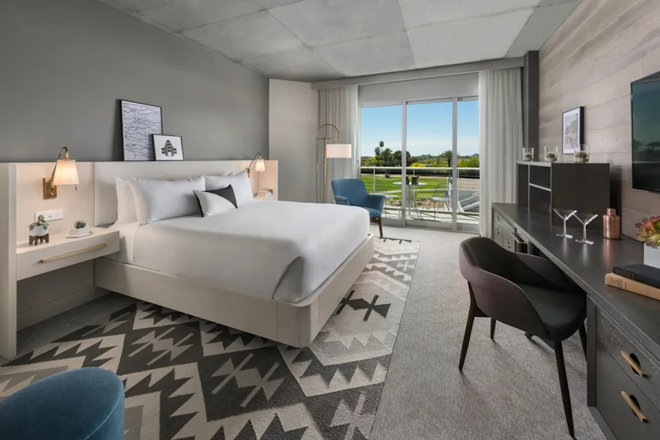 A king bed hotel room with muted tones