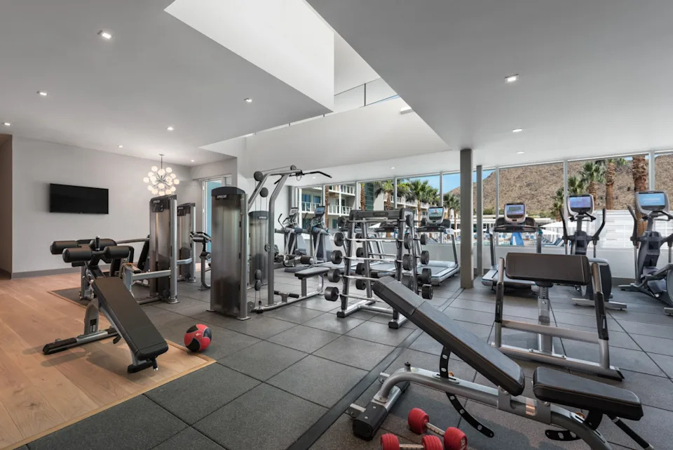 A fitness center with workout equipment and a view of the mountain through the window