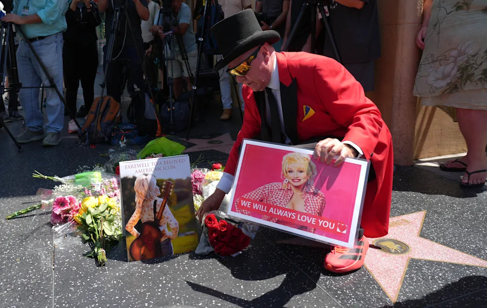 Actor Gregg Donovan kneels over Dolly Parton's star on the Hollywood Walk of Fame on Tuesday, Aug. 25, 2026, in Los Angeles. (AP Photo/Chris Pizzello)