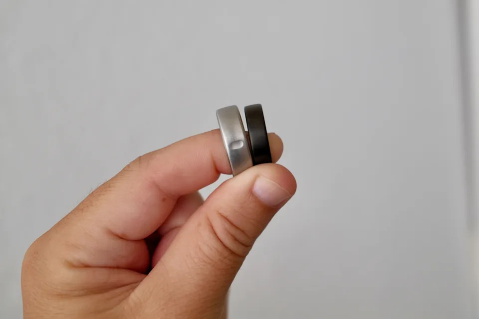 Hand holding Oura Ring 3 and Oura Ring 5