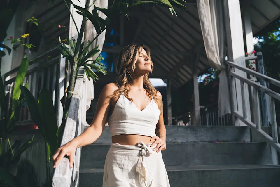 Person stepping outside into morning sun, illustrating how to start a wellness stack with an anchor habit