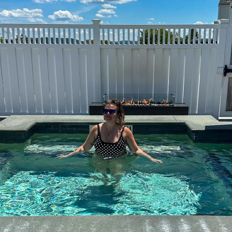 Woman in black swimsuit in an outdoor hot tub