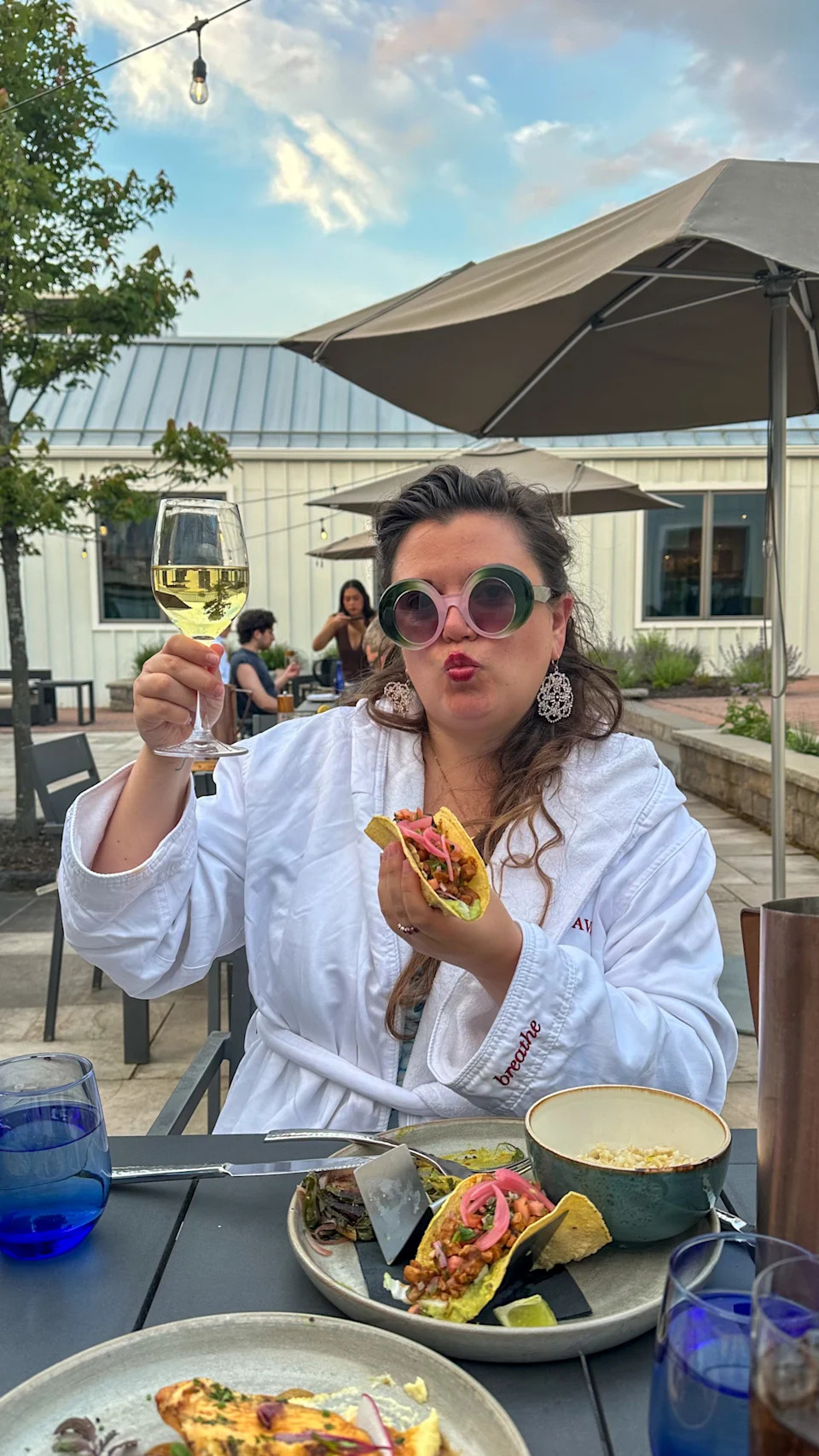 A woman holding a taco and wine at a wellness resort in Lenox, MA