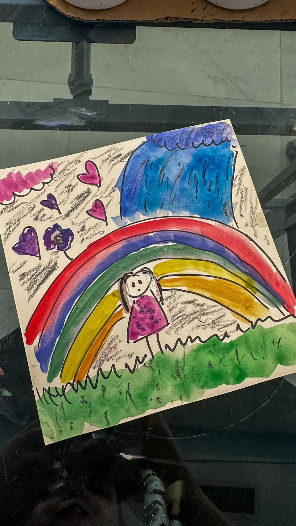 Painting of a girl in a purple dress with a rainbow, grass, and hearts