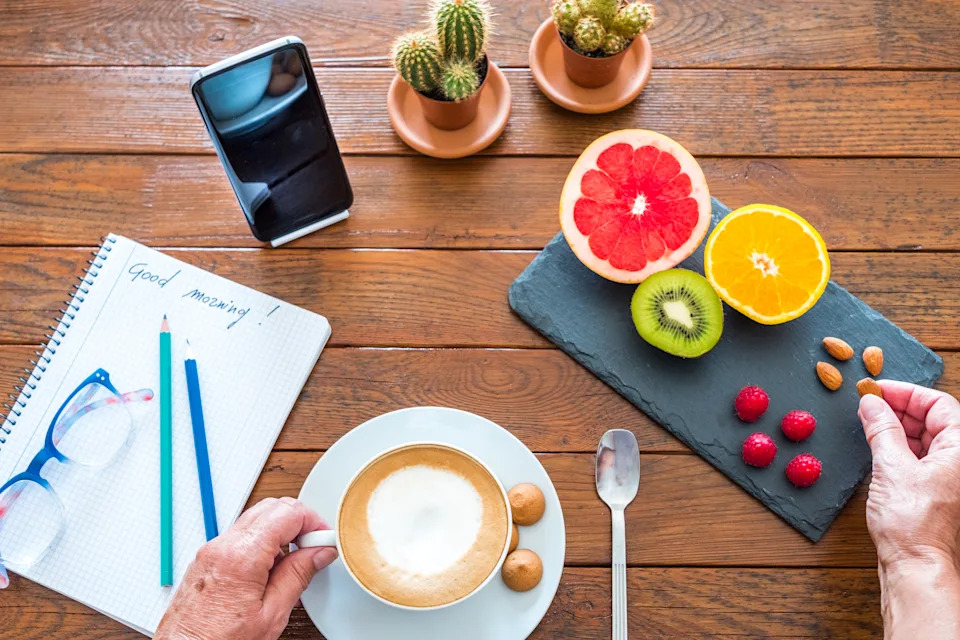 Coffee and journal arranged in a morning routine, illustrating wellness stacking