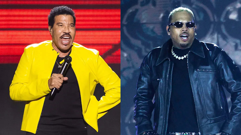Lionel Richie in a yellow jacket performing, and Chris Brown in a black jacket with sunglasses on stage.