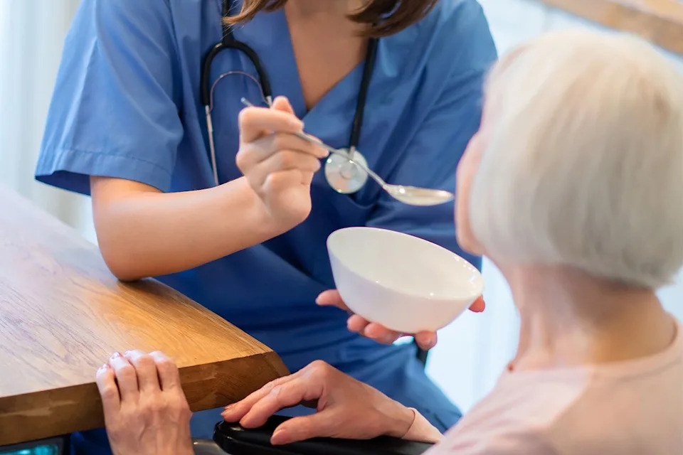 A woman being fed by a caregiver (stock image)Credit: Getty