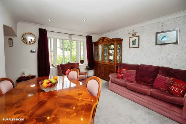 A bay-fronted living room features a ceiling-mounted surround sound system before flowing into the extended dining room