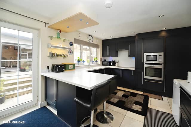 The open-plan dining kitchen combines fitted cabinetry, integrated appliances, attractive work surfaces and underfloor heating
