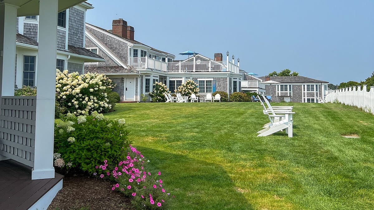 Large Nantucket shingle-style home with a manicured green lawn.