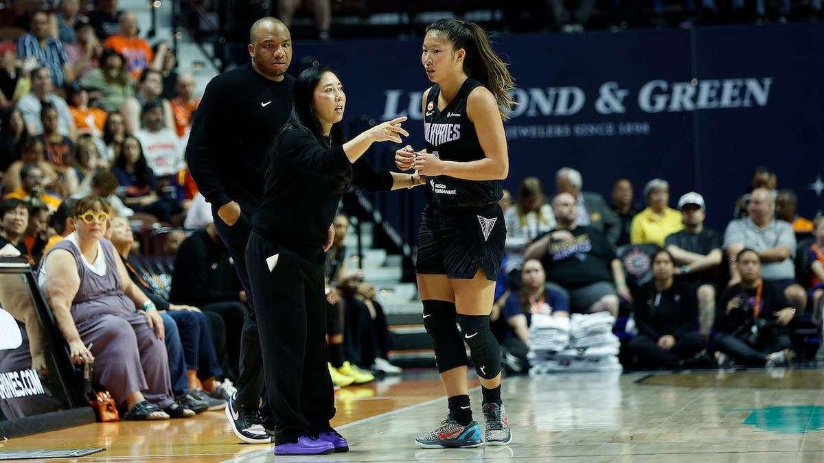 Natalie Nakase speaks with Kaitlyn Chen during a WNBA game.