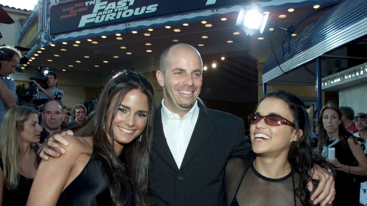 Neal Moritz, Jordana Brewster, and Michelle Rodriguez stand together at a film premiere.