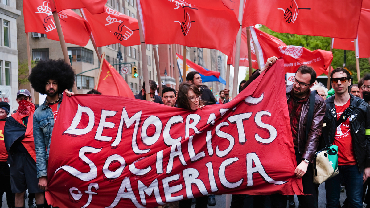 NEW YORK, NEW YORK - MAY 01: Members of the Democratic Socialists of America gather outside of a Trump owned building on May Day on May