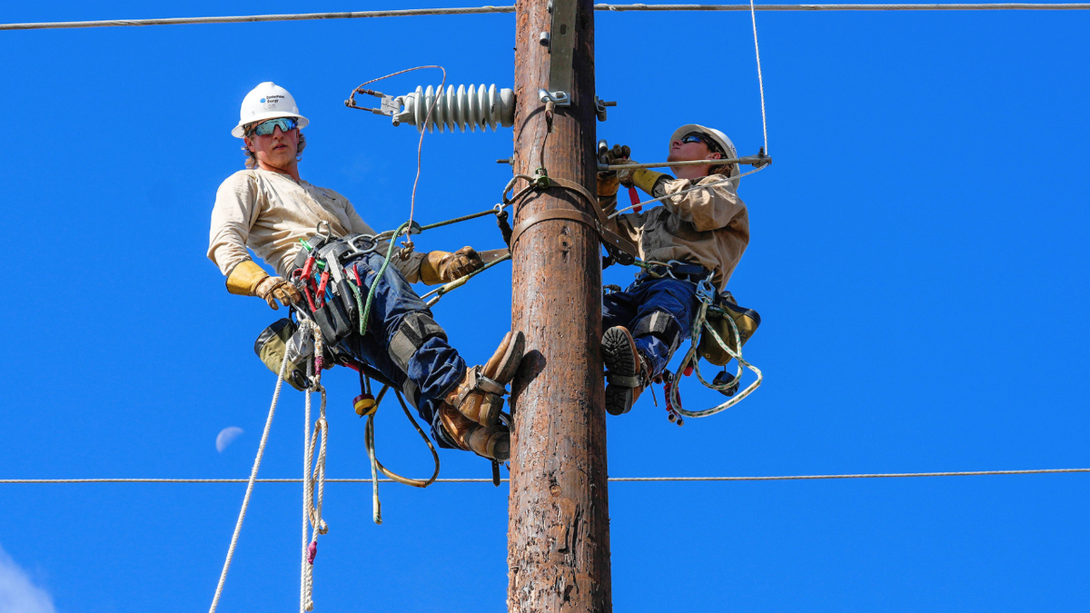 Men are seen working on a power line in Houston, Texas.