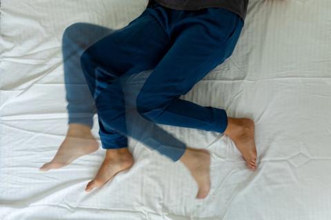 A person’s legs shifting back and forth in bed