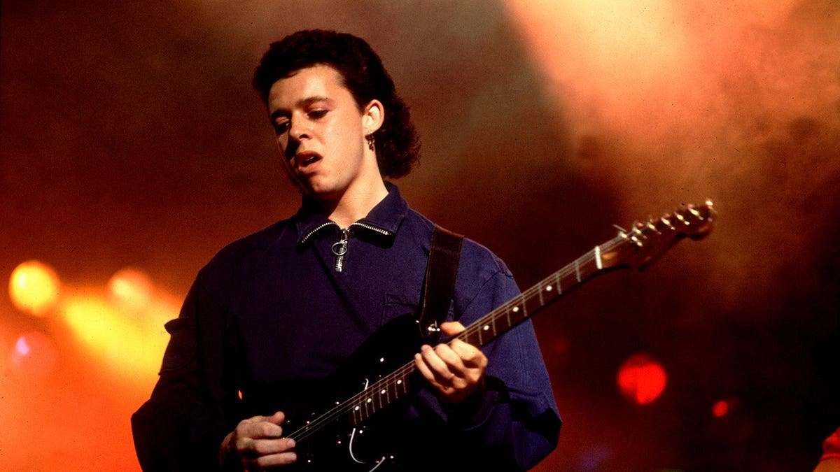 Roland Orzabal plays guitar while performing onstage at the Aragon Ballroom.