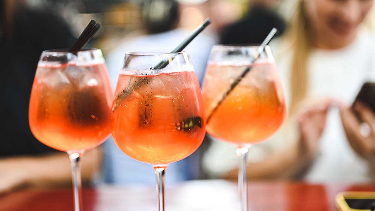 Three fresh cocktails sit on a table.