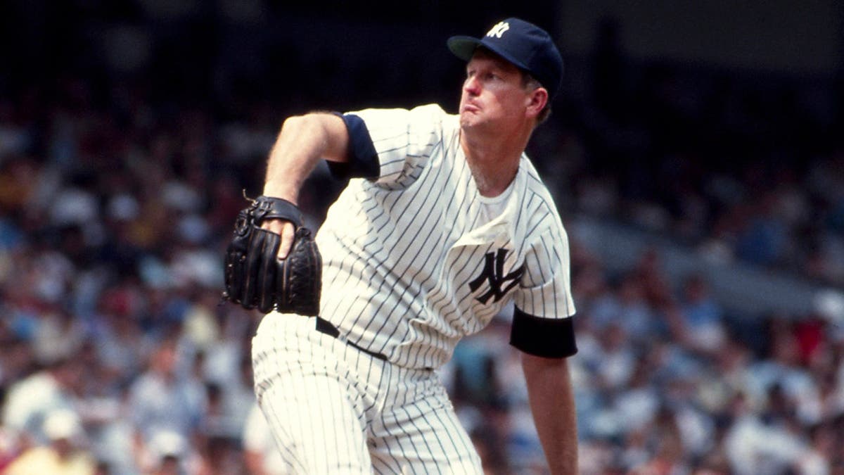 Tommy John delivers a pitch during a Yankees game at Yankee Stadium.