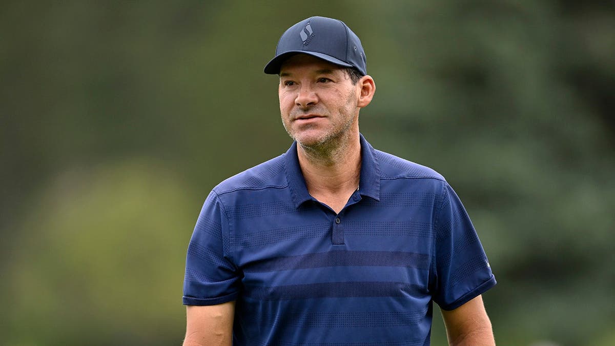 Tony Romo stands on the first green during a golf tournament.