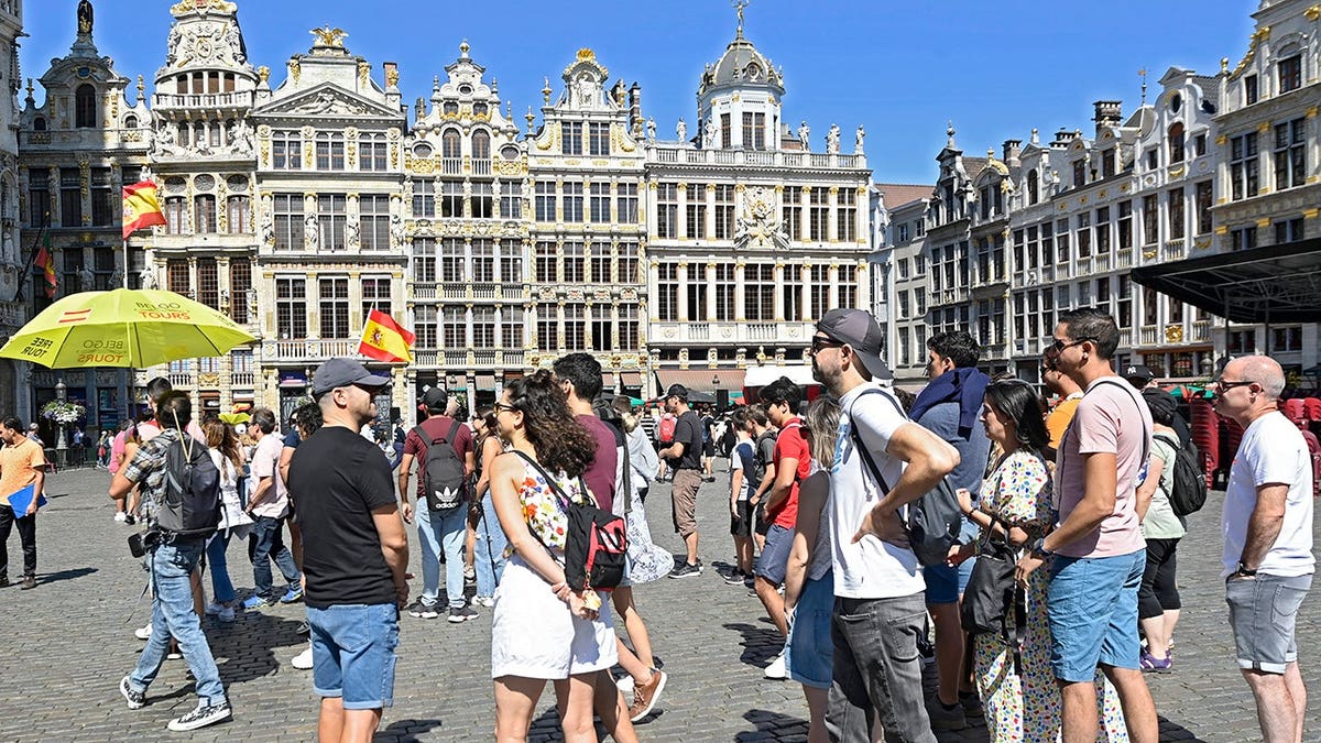Tourists walk through a street in Brussels, Belgium.