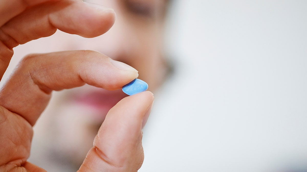 man holds viagra pill
